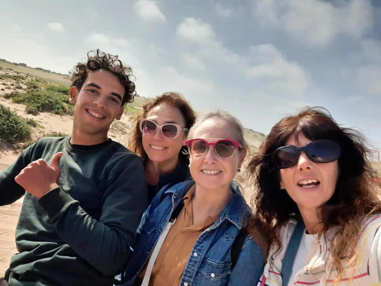 Ayoub the local guide helping international tourists prepare for sandboarding down the massive Timlalin Dunes