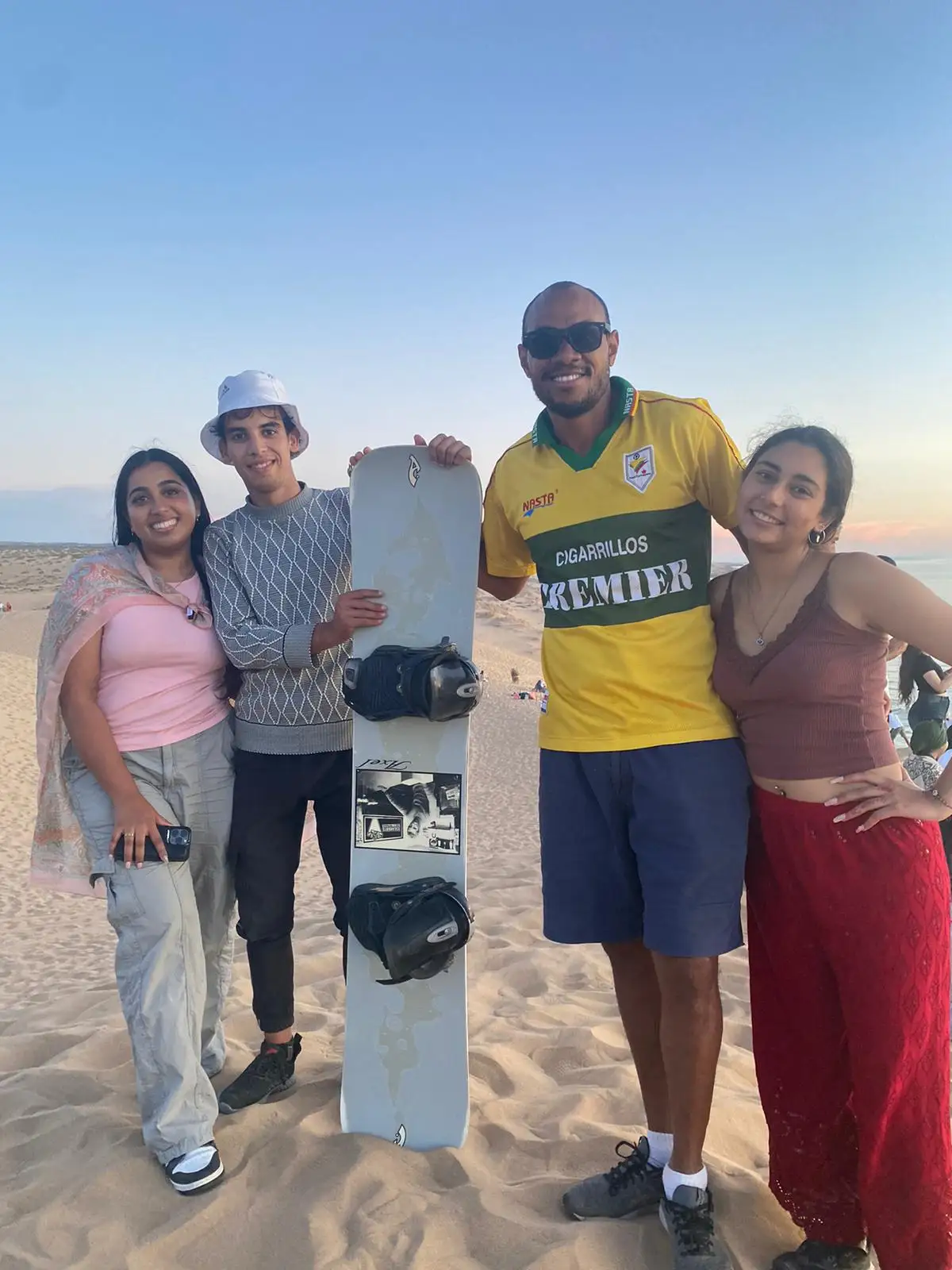 Ayoub with his travel guests enjoying an authentic Moroccan sunset tea and ocean view experience at Timlalin Dunes
